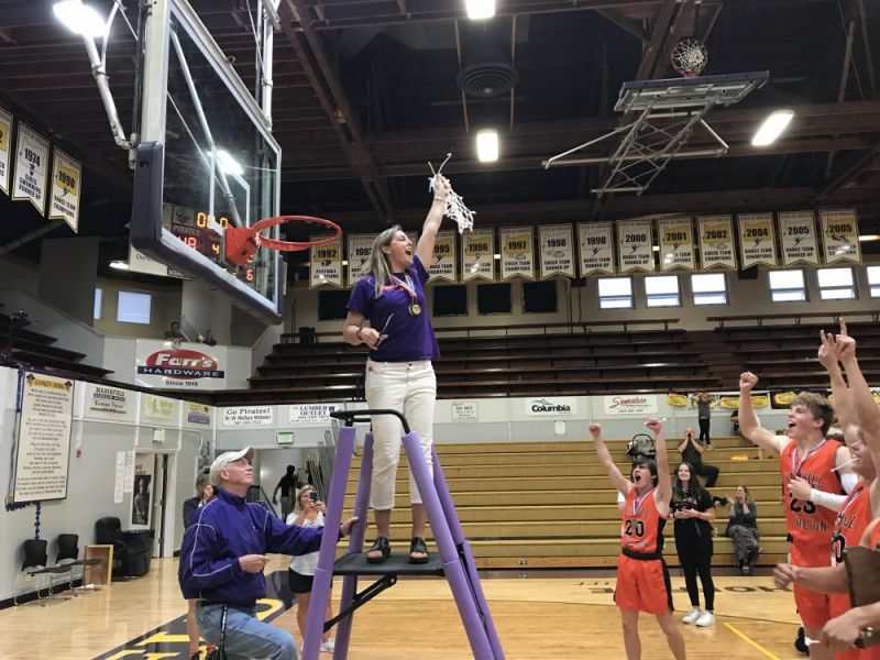 Photo courtesy John Gunther/The World##
Yamhill-Carlton head coach Heather Roberts holds up the net as her players cheer following the Tigers’ win over Cascade Christian in the state championship game at Marshfield High School.